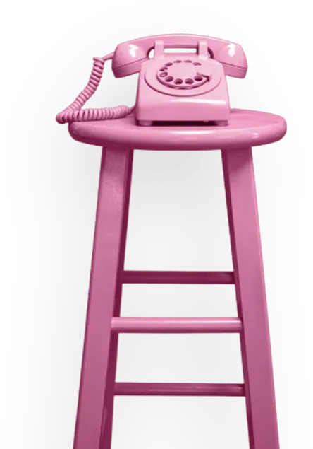 Old-school rotary phone on a large stool, all in a singular pink color